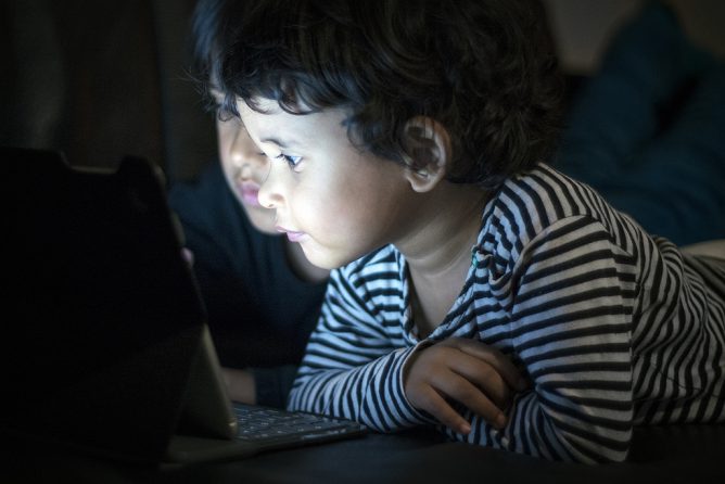 子供がパソコンを見ている画像